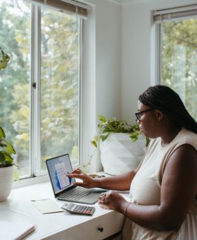 woman working from home at a desk by a window.