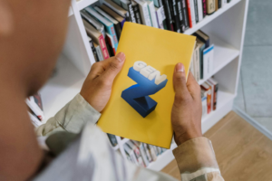 Person holding a yellow book with a 3D staircase graphic representing career development.