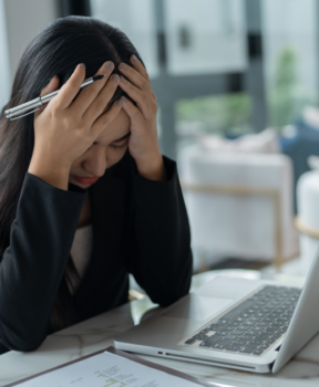 HR support for those businesses in the Cayman Islands that have a stretched HR team or no HR team at all. Image shows a lady with her head in her hands in stress.