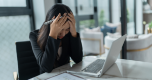 HR support for those businesses in the Cayman Islands that have a stretched HR team or no HR team at all. Image shows a lady with her head in her hands in stress.