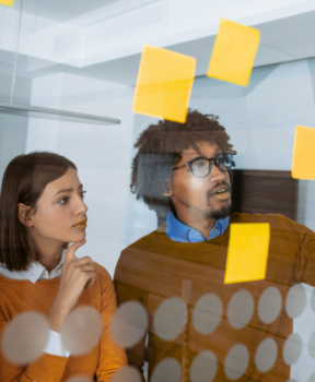 A group of colleagues brainstorming against a clear board.